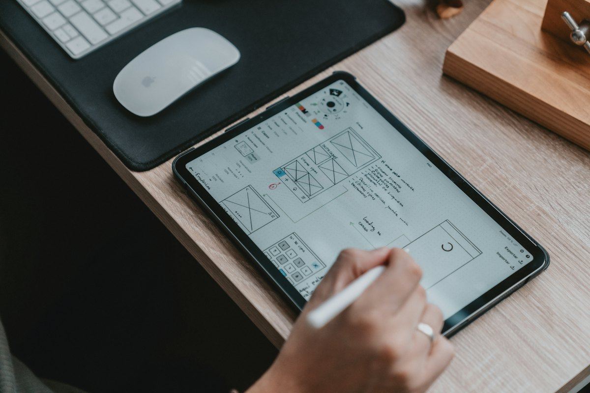 Hand sketching a website wireframe on a tablet
